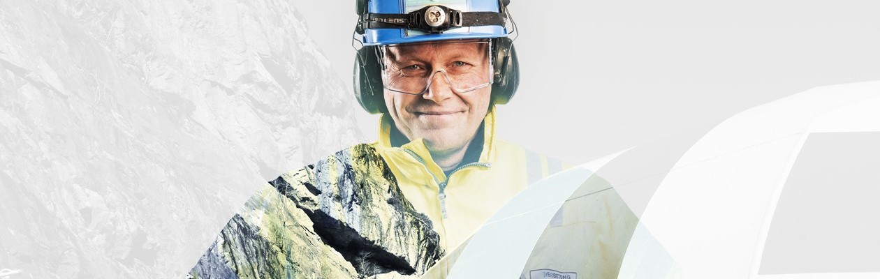 Mann i arbeidskler smiler tilbake til kamera